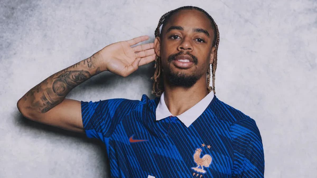Jugador posando con camiseta de Francia y gesto de escucha