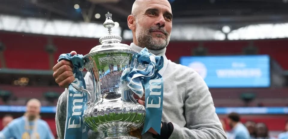 Entrenador sosteniendo el trofeo en Wembley