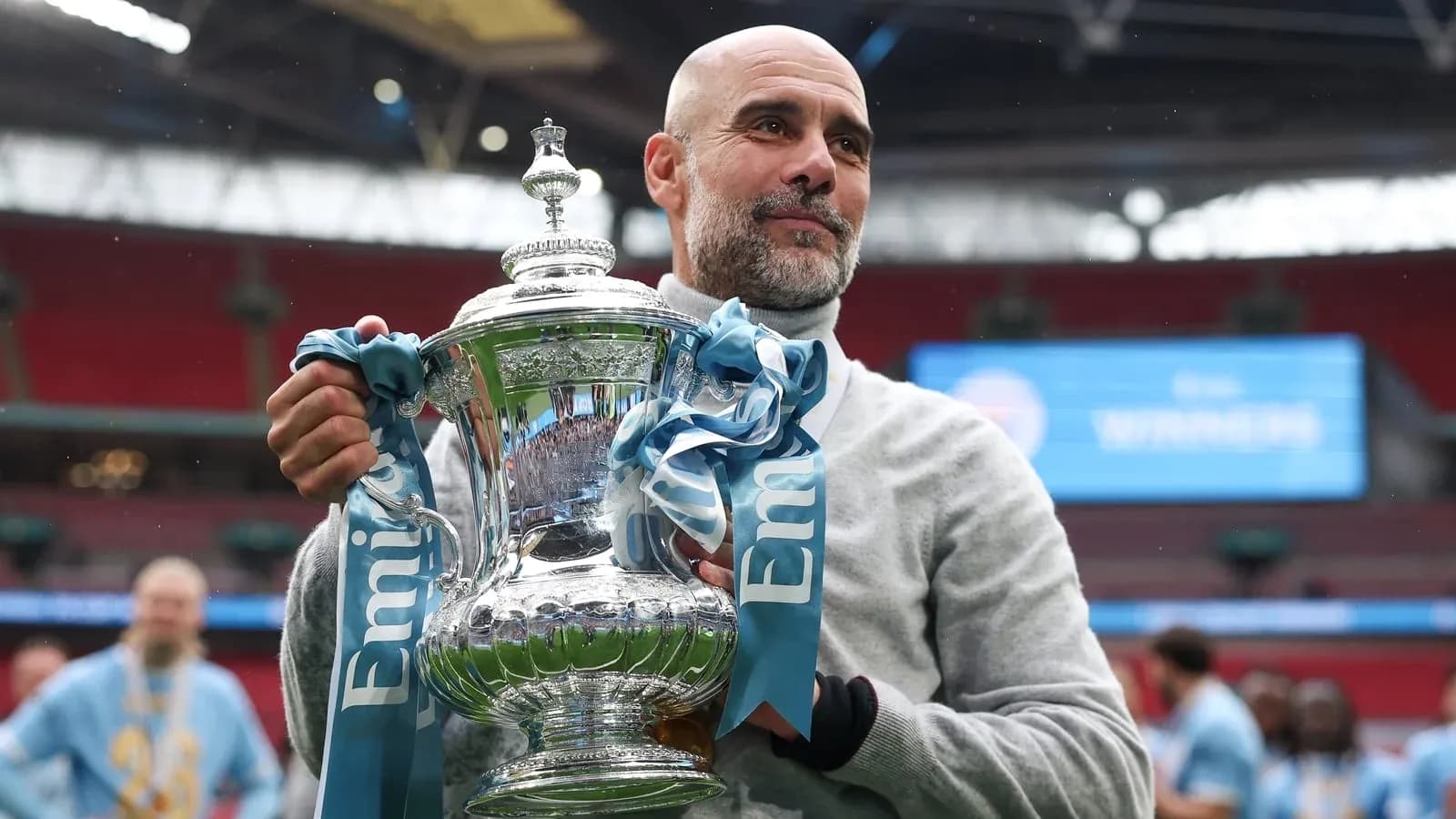 Entrenador sosteniendo el trofeo en Wembley