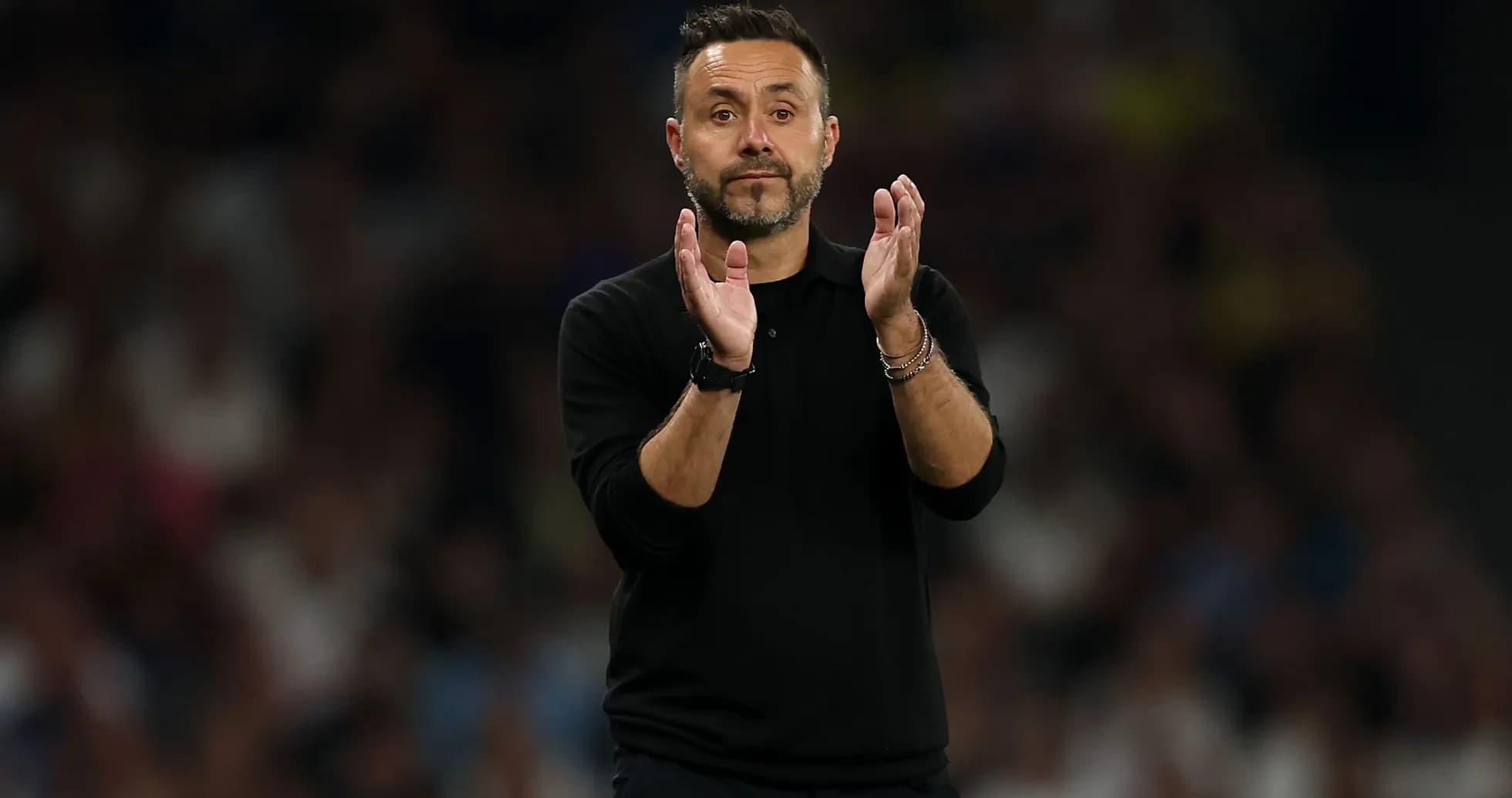 Entrenador aplaudiendo durante un partido de fútbol