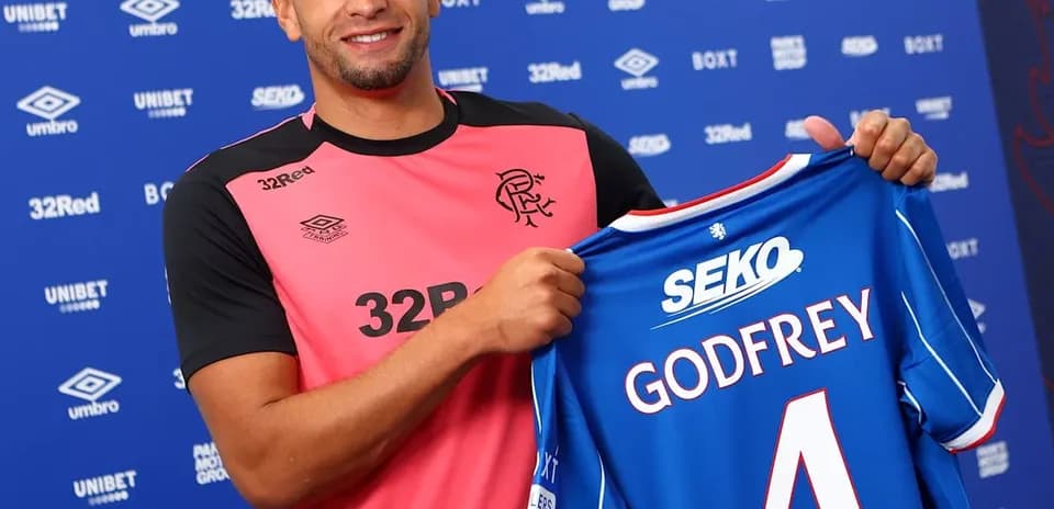 Jugador sosteniendo camiseta de Rangers con su nombre
