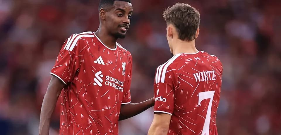 Jugadores de Liverpool conversando en el campo