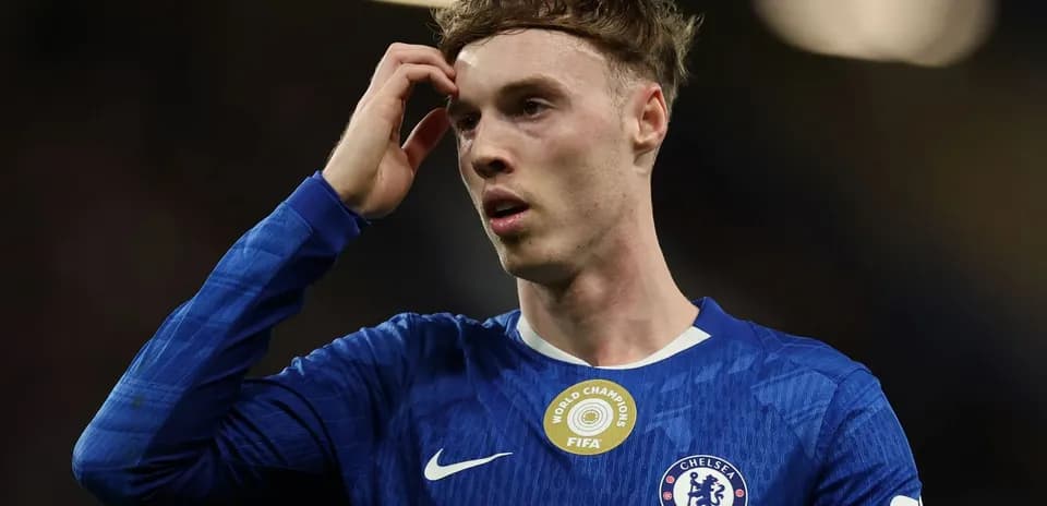 Jugador de Chelsea con camiseta azul tocándose la cabeza