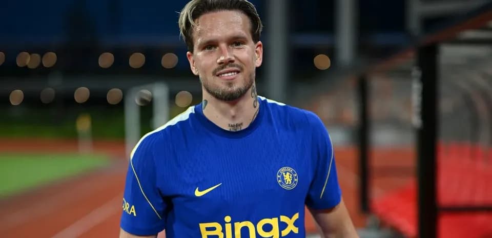 Jugador sonriente con camiseta de Chelsea en el campo