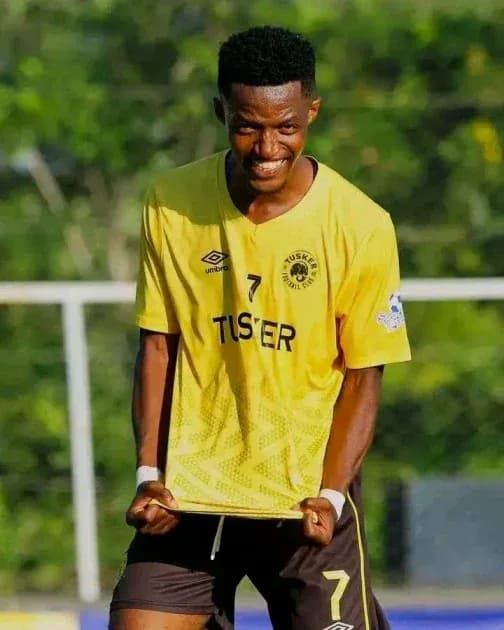 Jugador de fútbol sonriendo en uniforme amarillo