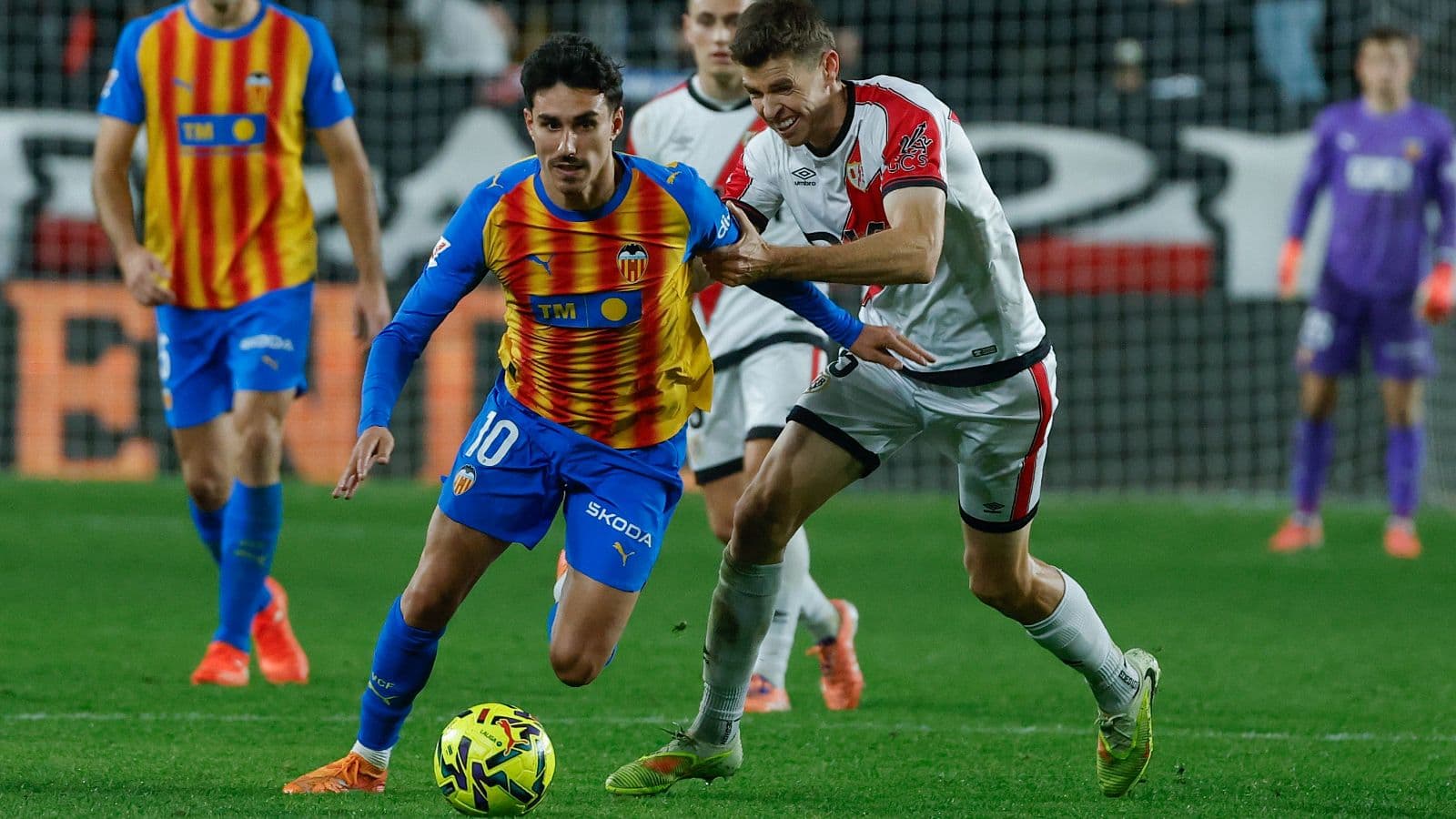Jugador de Valencia driblando a rival de Rayo Vallecano