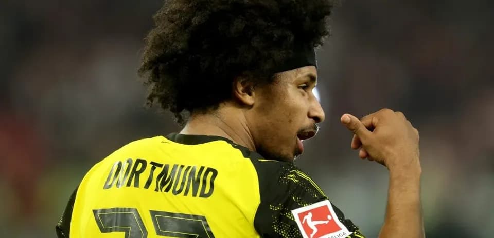 Jugador de Dortmund señalando su camiseta durante el partido