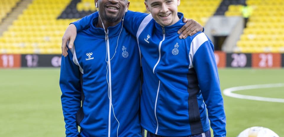 Dos jugadores posando juntos en el campo de fútbol