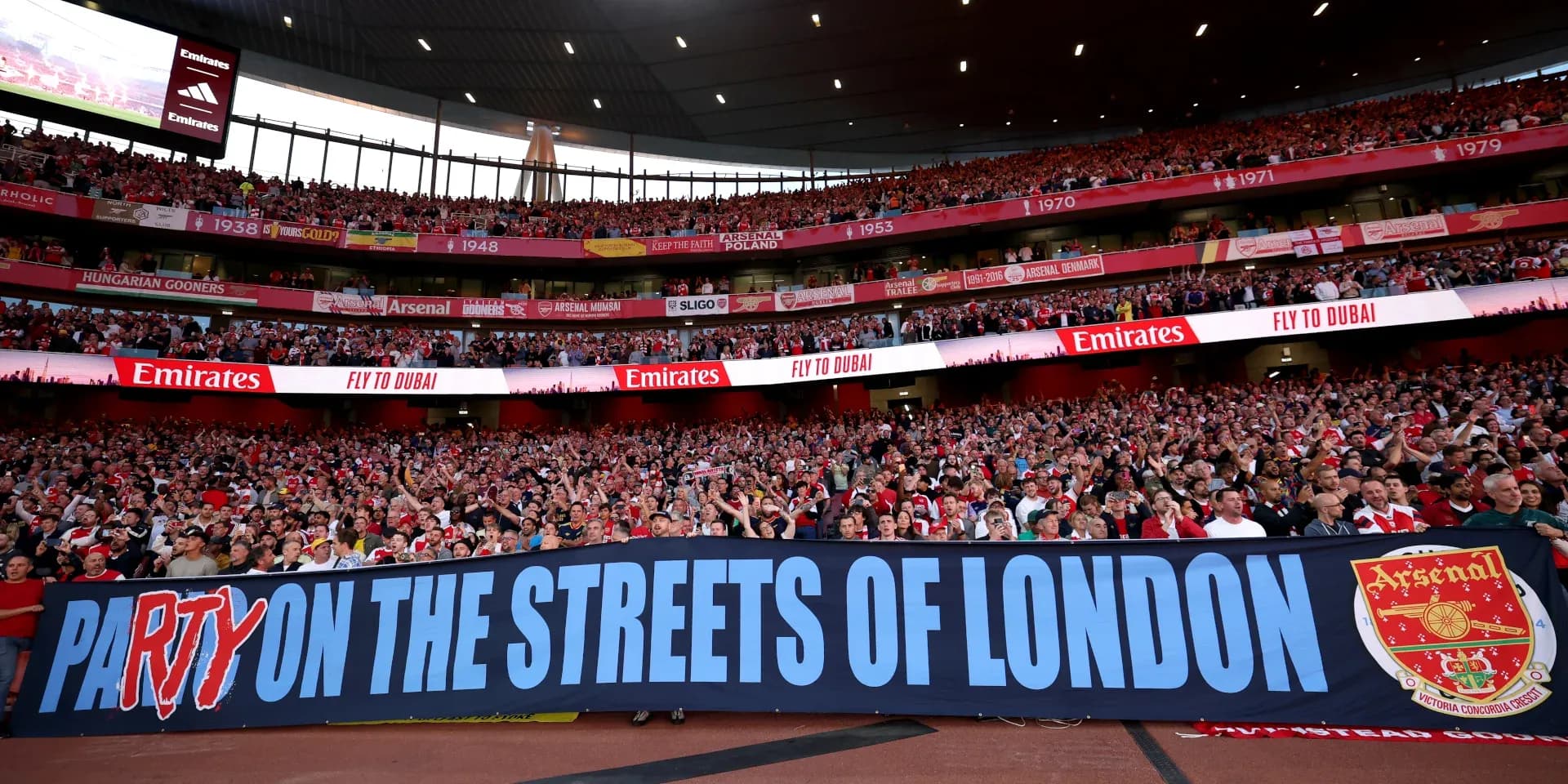 Aficionados de Arsenal con pancarta en el estadio