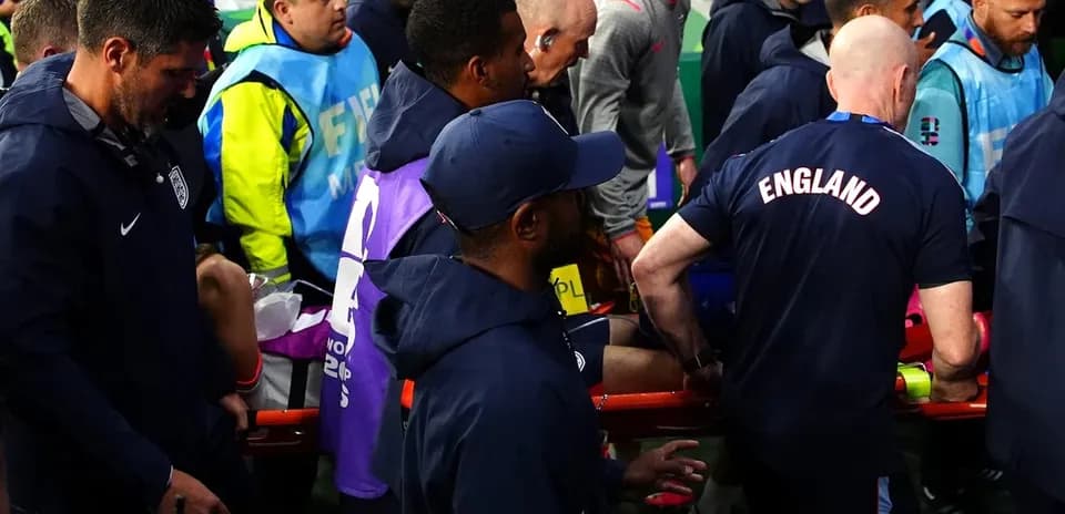 Jugadores y personal ayudando a un herido en el campo