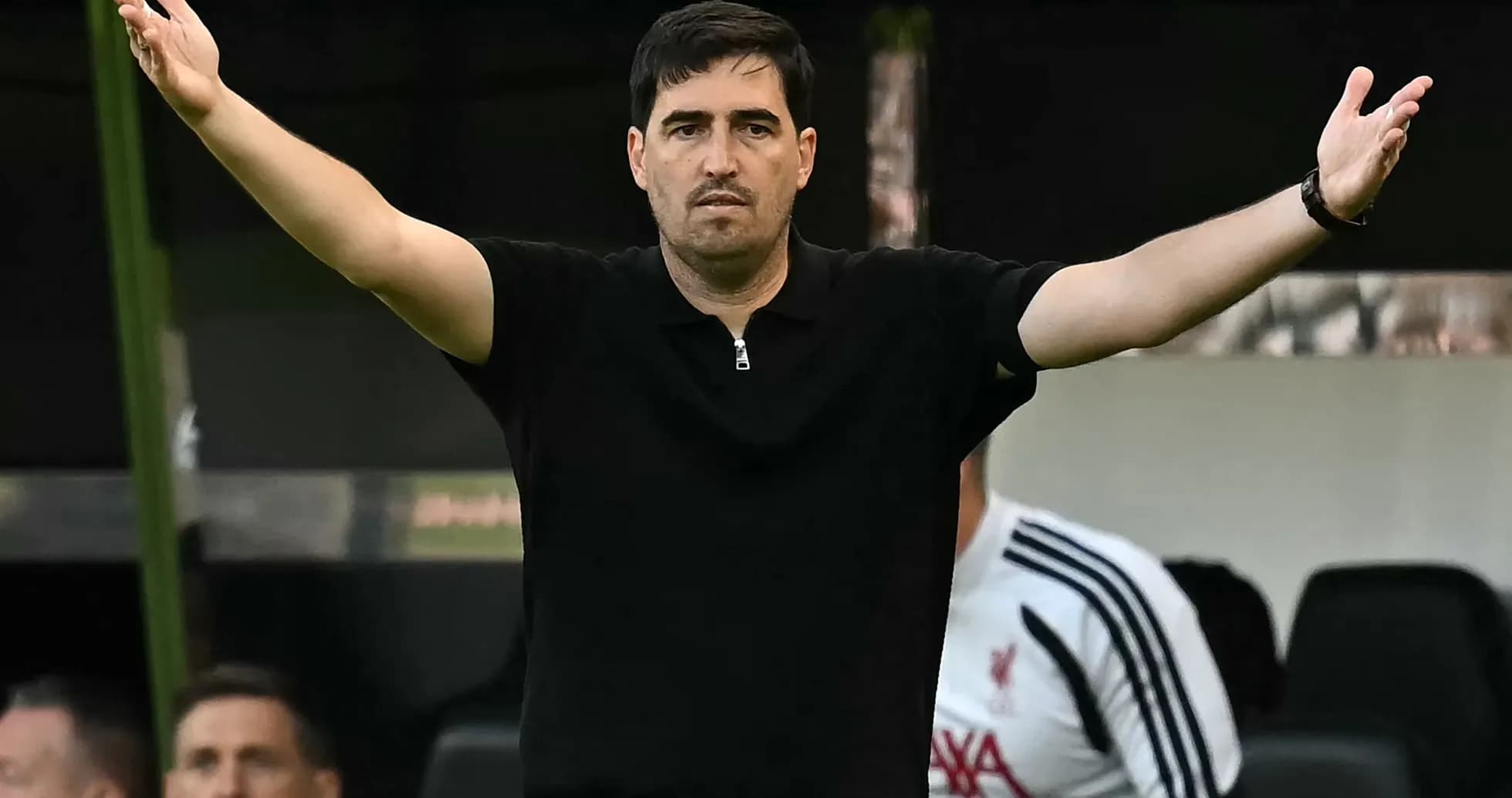 Entrenador gesticulando desde la banca durante el partido