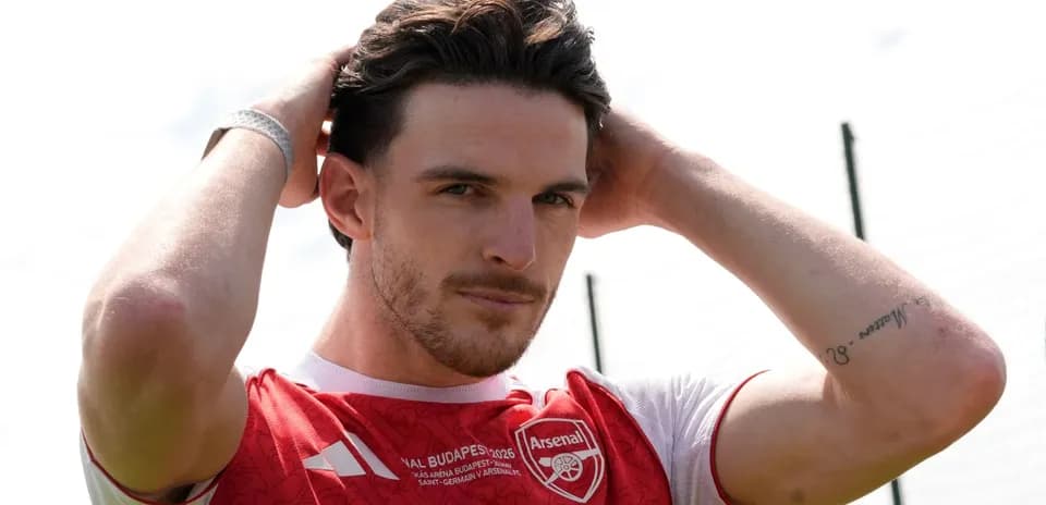 Jugador de Arsenal ajustando su cabello en el campo