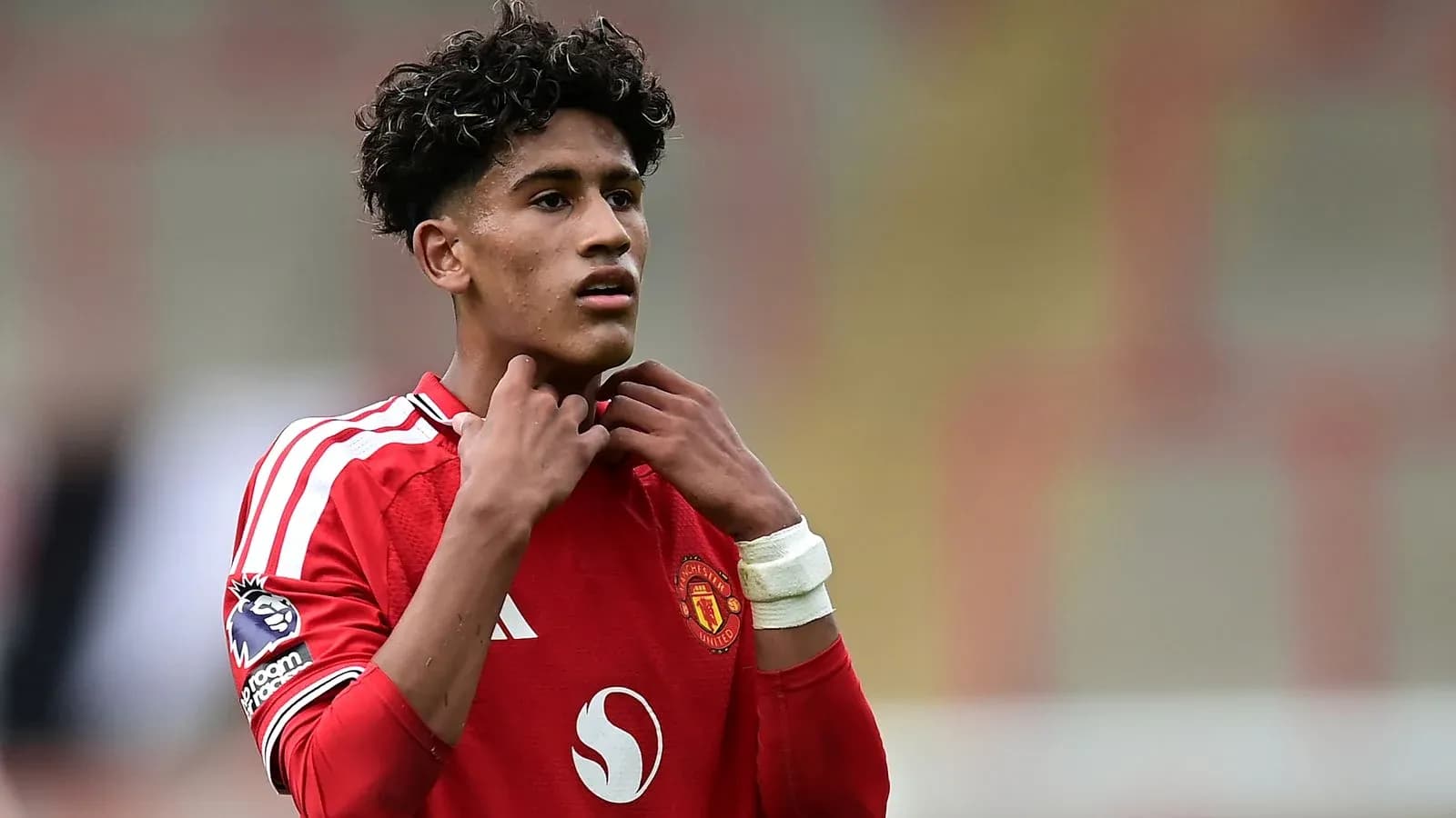 Jugador de Manchester United ajustándose el collar del uniforme