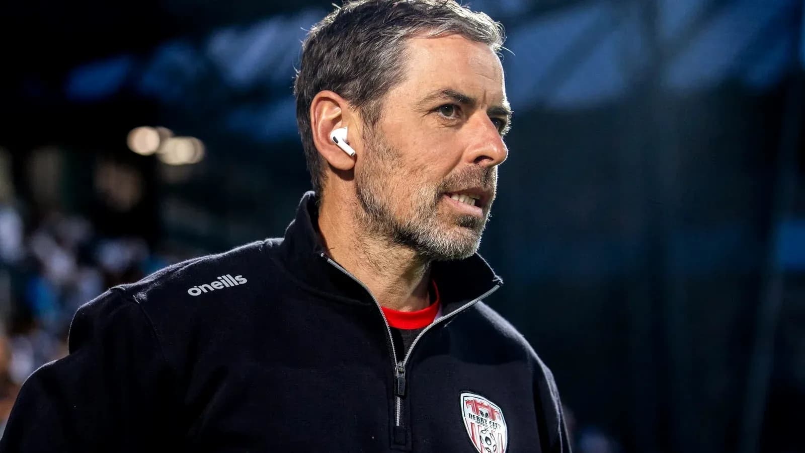Entrenador con auriculares en el campo de juego