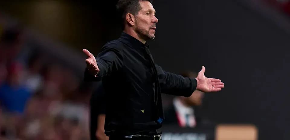 Entrenador gesticulando durante un partido de fútbol