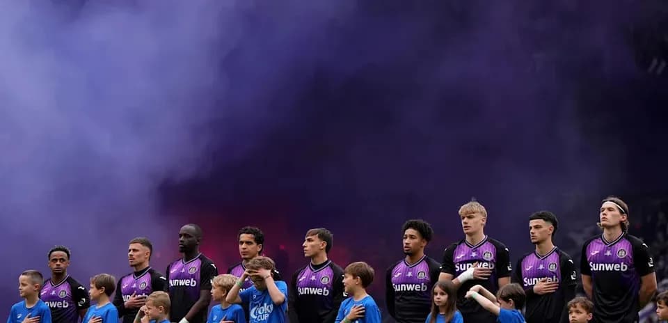Jugadores y niños de pie durante el himno