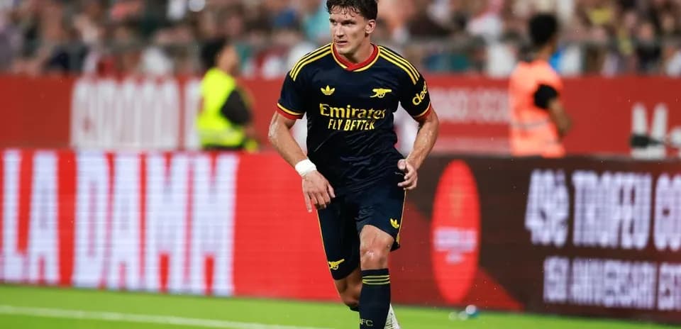 Jugador de Arsenal corriendo con el balón en campo