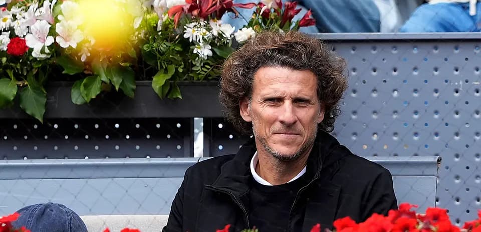 Hombre sentado en gradas rodeado de flores