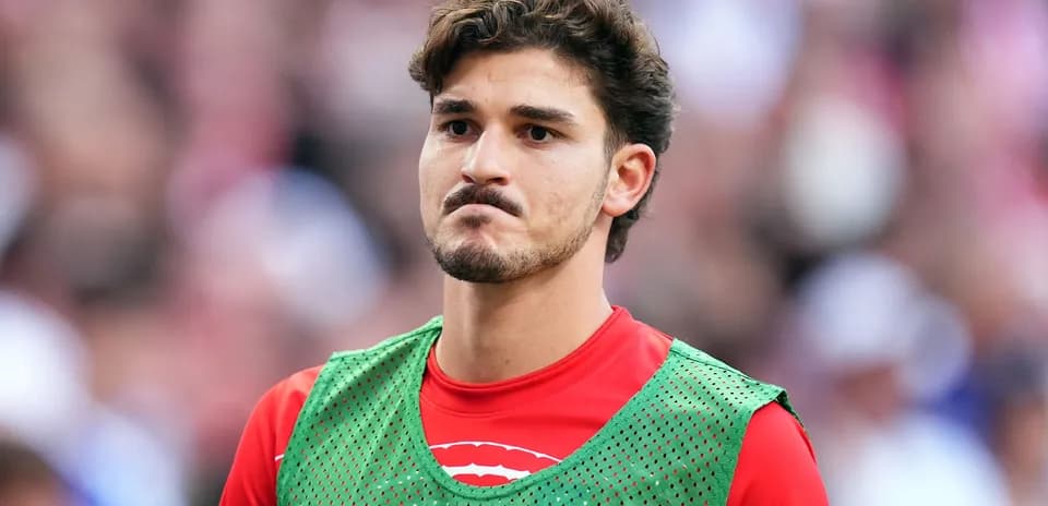 Jugador en la banca con pechera verde durante el partido
