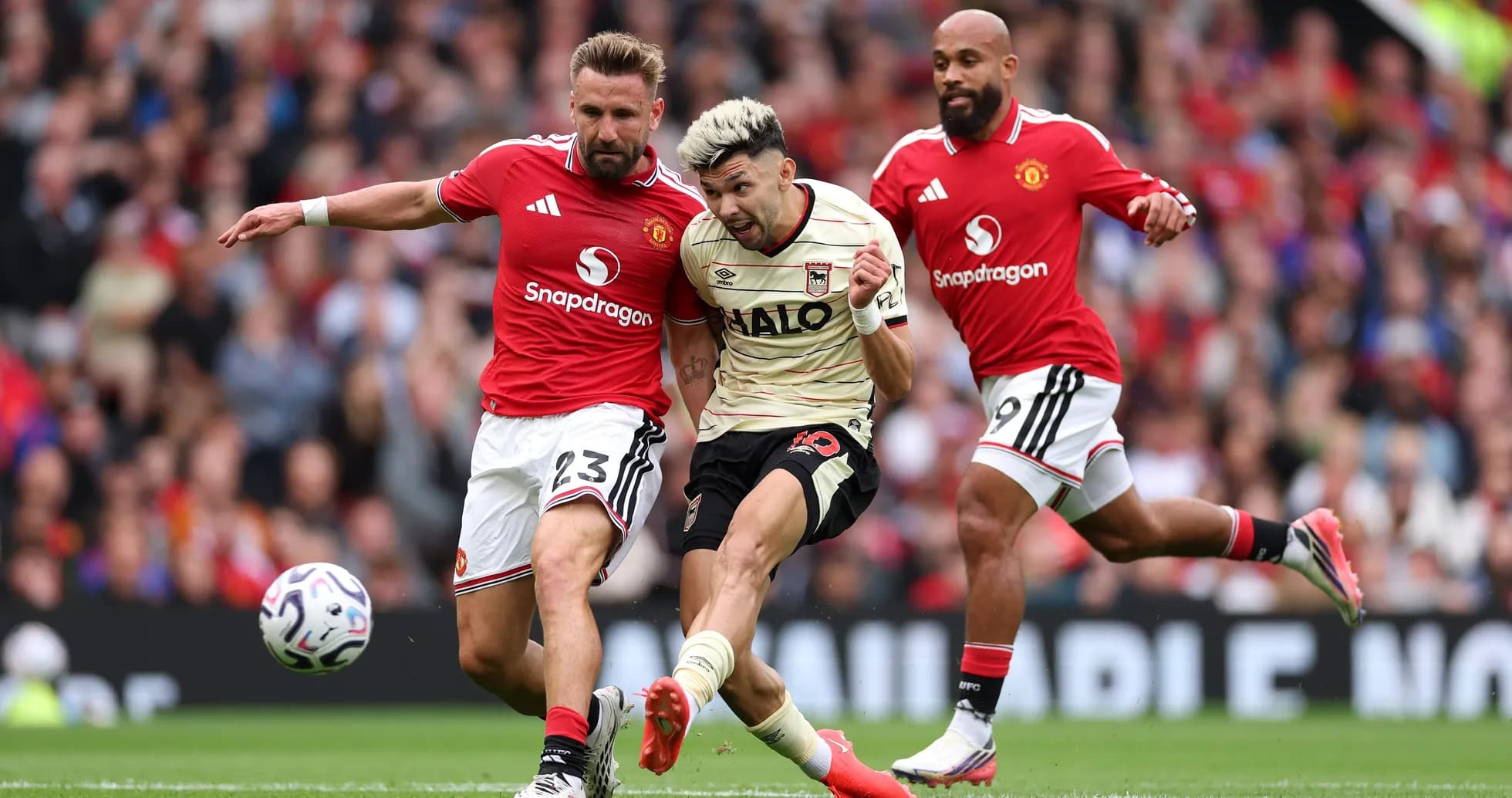 Jugador de Ipswich siendo tackleado por defensor de Manchester United