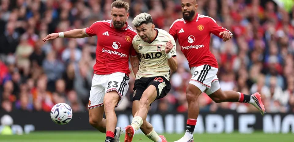 Jugador de Ipswich siendo tackleado por defensor de Manchester United