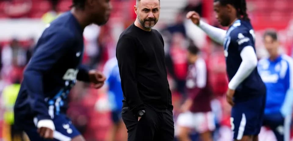 Entrenador observando a jugadores durante el calentamiento