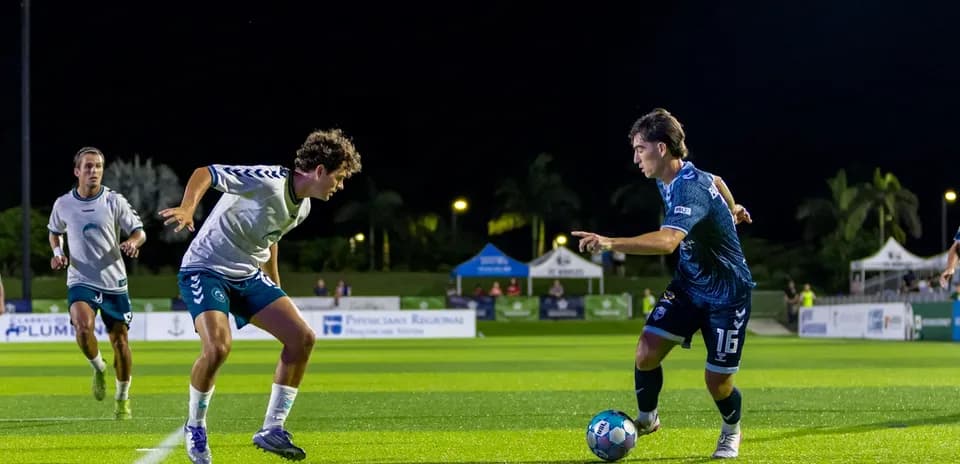 Jugador de fútbol driblando a oponente en el campo