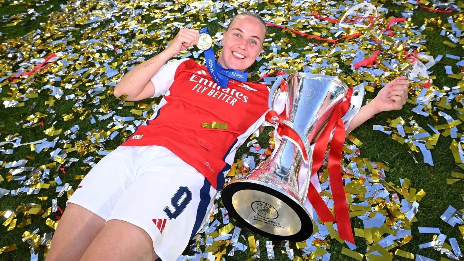 Jugadora de Arsenal celebrando con trofeo y medalla Jugadora de Arsenal celebrando con trofeo y medalla