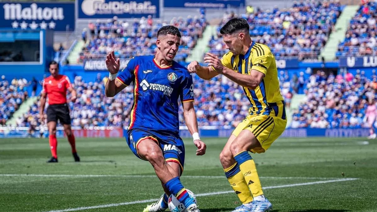 Jugador de Getafe driblando a un oponente Jugador de Getafe driblando a un oponente