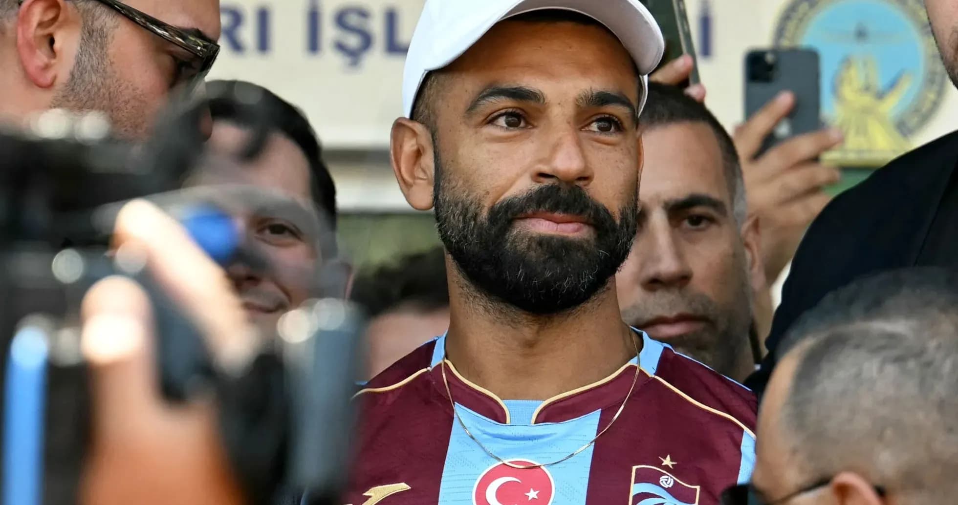 Jugador en camiseta de Trabzonspor rodeado de periodistas Jugador en camiseta de Trabzonspor rodeado de periodistas
