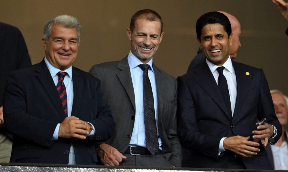 Tres directivos sonriendo en un evento deportivo Tres directivos sonriendo en un evento deportivo