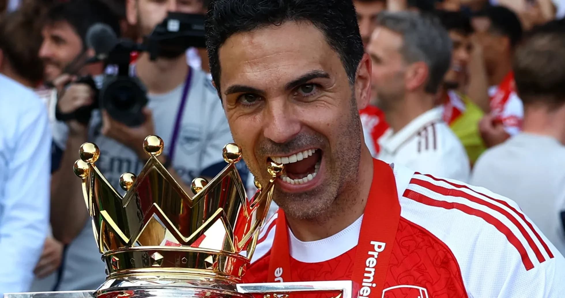 Entrenador sosteniendo trofeo de Premier League en celebración Entrenador sosteniendo trofeo de Premier League en celebración