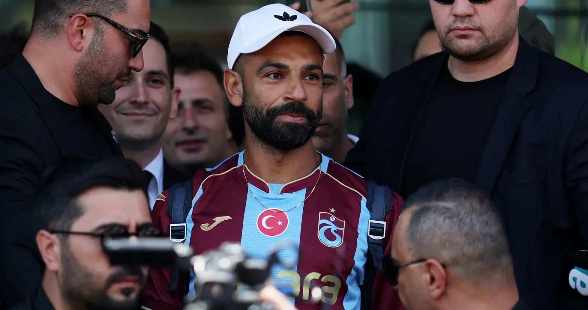 Jugador de Trabzonspor rodeado de seguridad en evento Jugador de Trabzonspor rodeado de seguridad en evento