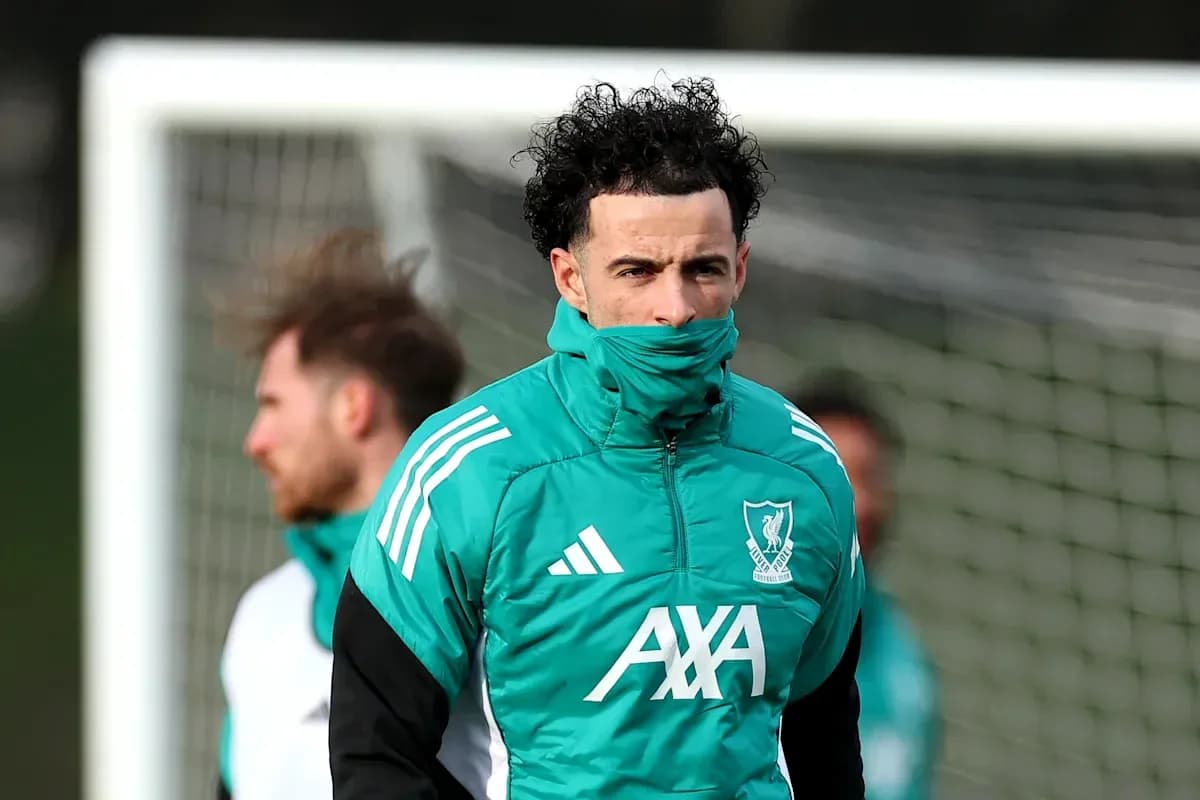 Jugador entrenando con abrigo de Liverpool en campo Jugador entrenando con abrigo de Liverpool en campo
