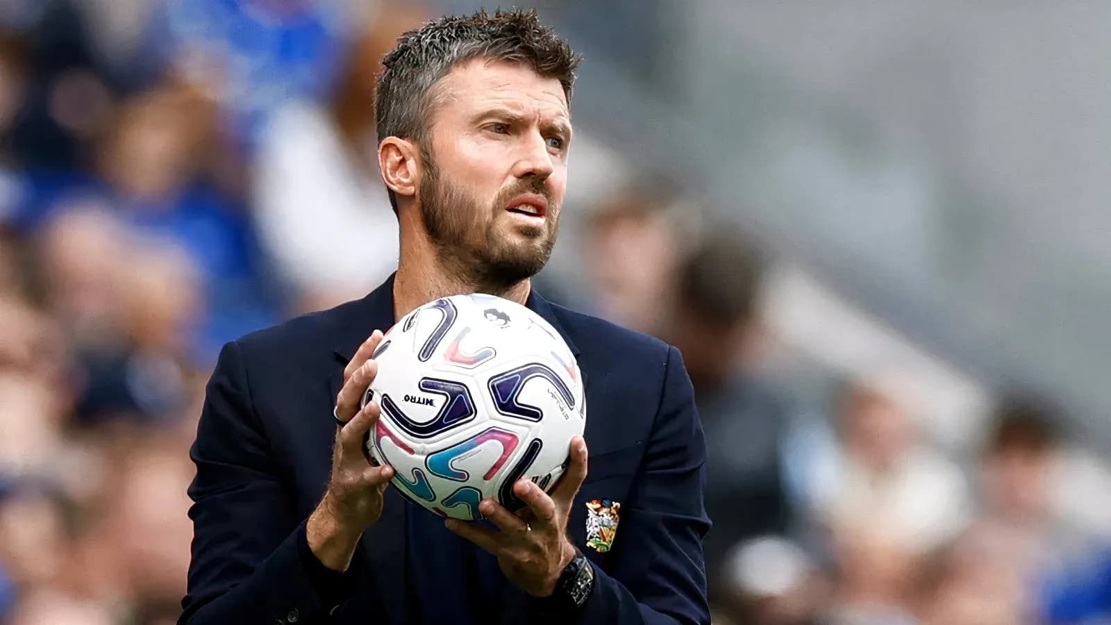 Entrenador sosteniendo un balón durante el partido Entrenador sosteniendo un balón durante el partido