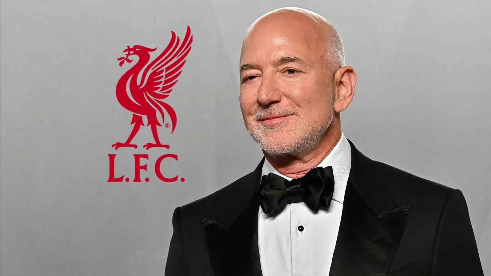 Hombre vestido de gala junto al logo de Liverpool Hombre vestido de gala junto al logo de Liverpool