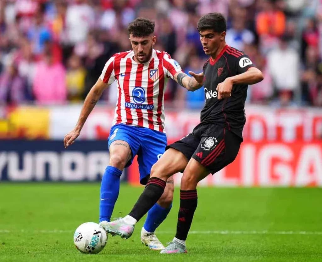 Dos jugadores compitiendo por el balón en La Liga Dos jugadores compitiendo por el balón en La Liga