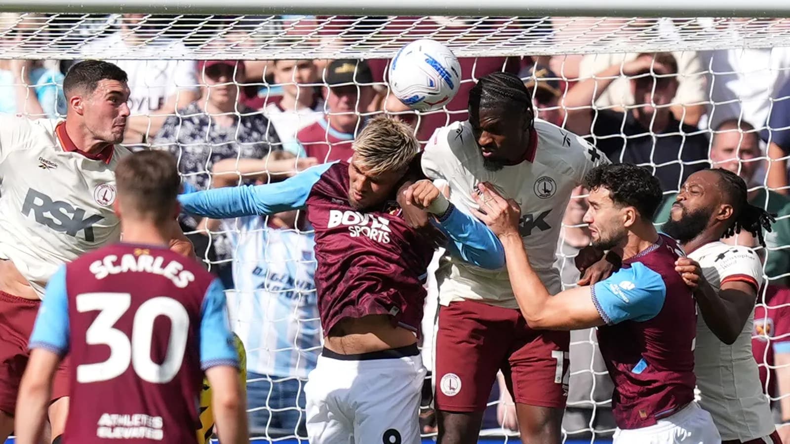 Jugadores disputando un balón en el área de gol Jugadores disputando un balón en el área de gol