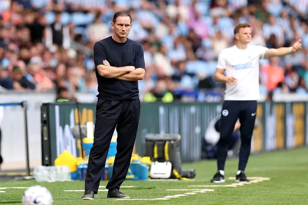 Entrenador observando el partido desde la línea lateral Entrenador observando el partido desde la línea lateral