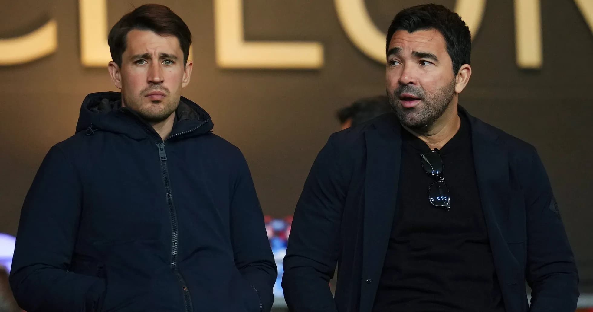 Dos hombres sentados en un palco de estadio Dos hombres sentados en un palco de estadio