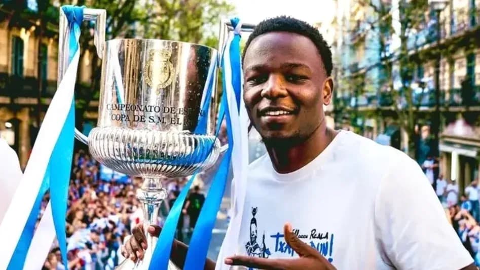 Jugador sosteniendo trofeo en celebración callejera Jugador sosteniendo trofeo en celebración callejera