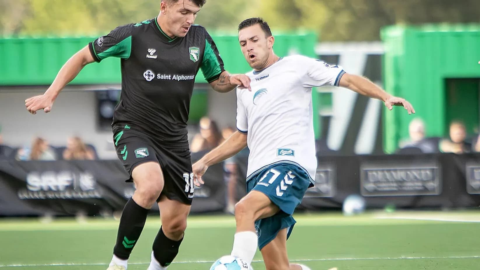 Dos jugadores compitiendo por el balón Dos jugadores compitiendo por el balón
