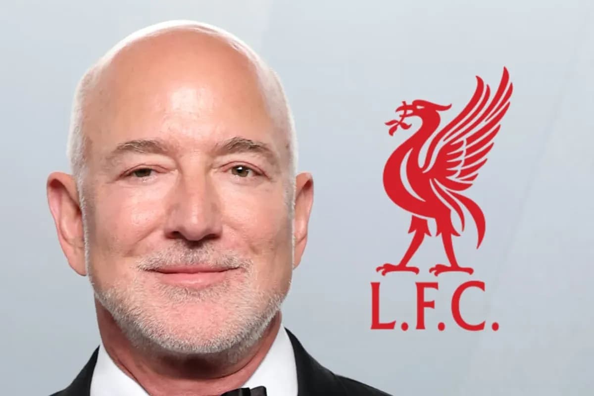 Hombre sonriendo con logo de Liverpool detrás Hombre sonriendo con logo de Liverpool detrás