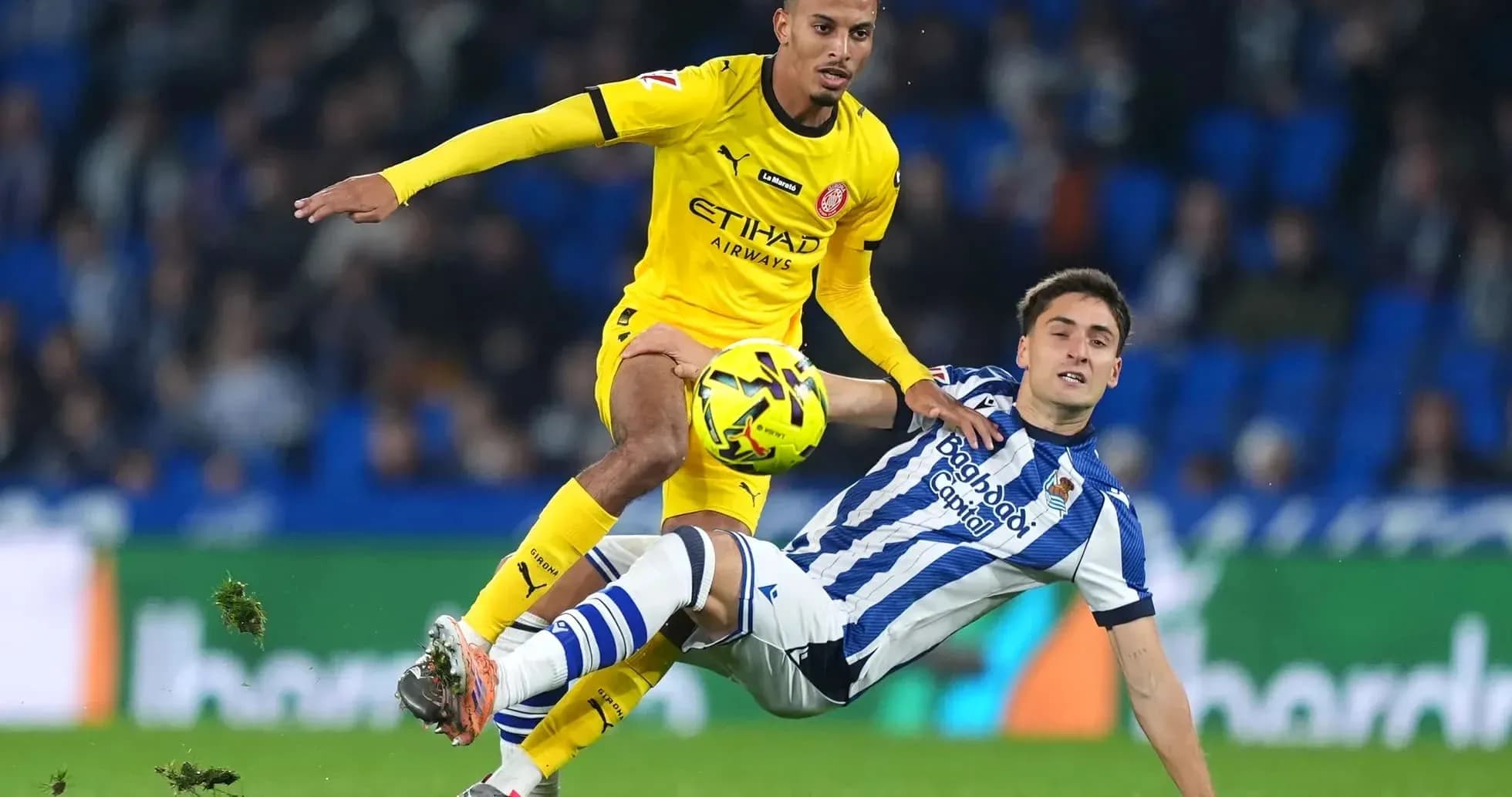 Jugador de Girona desafiando a un rival de la Real Sociedad Jugador de Girona desafiando a un rival de la Real Sociedad