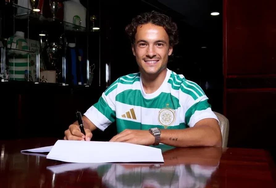 Jugador firmando contrato en mesa con camiseta del Celtic Jugador firmando contrato en mesa con camiseta del Celtic