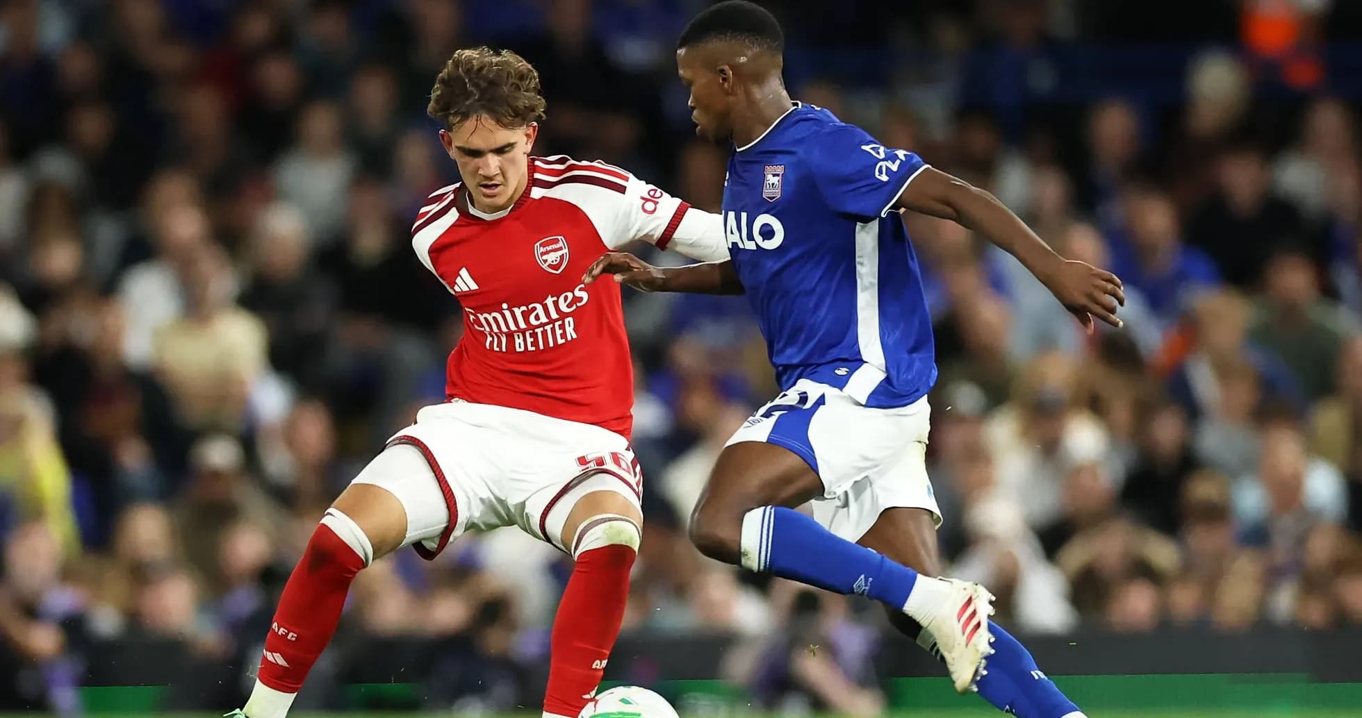 Jugador de Arsenal desafiando a jugador de Ipswich Town Jugador de Arsenal desafiando a jugador de Ipswich Town
