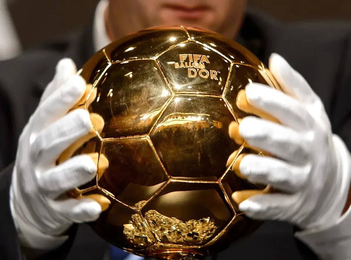 Trofeo Balón de Oro sostenido por una persona Trofeo Balón de Oro sostenido por una persona