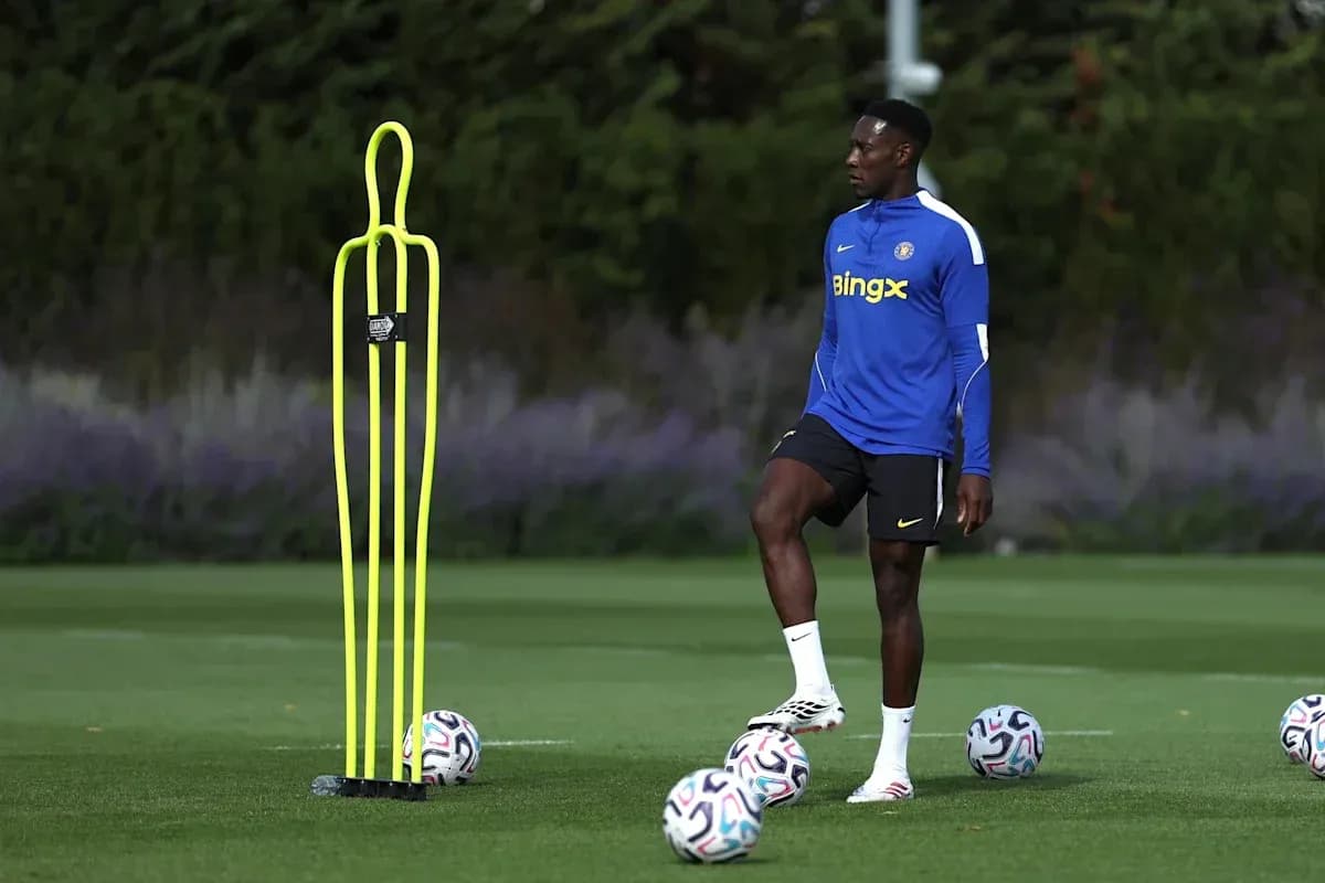 Jugador entrenando junto a conos y balones de fútbol Jugador entrenando junto a conos y balones de fútbol