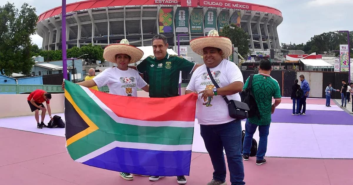 Tres aficionados sosteniendo bandera de Sudáfrica en estadio Tres aficionados sosteniendo bandera de Sudáfrica en estadio