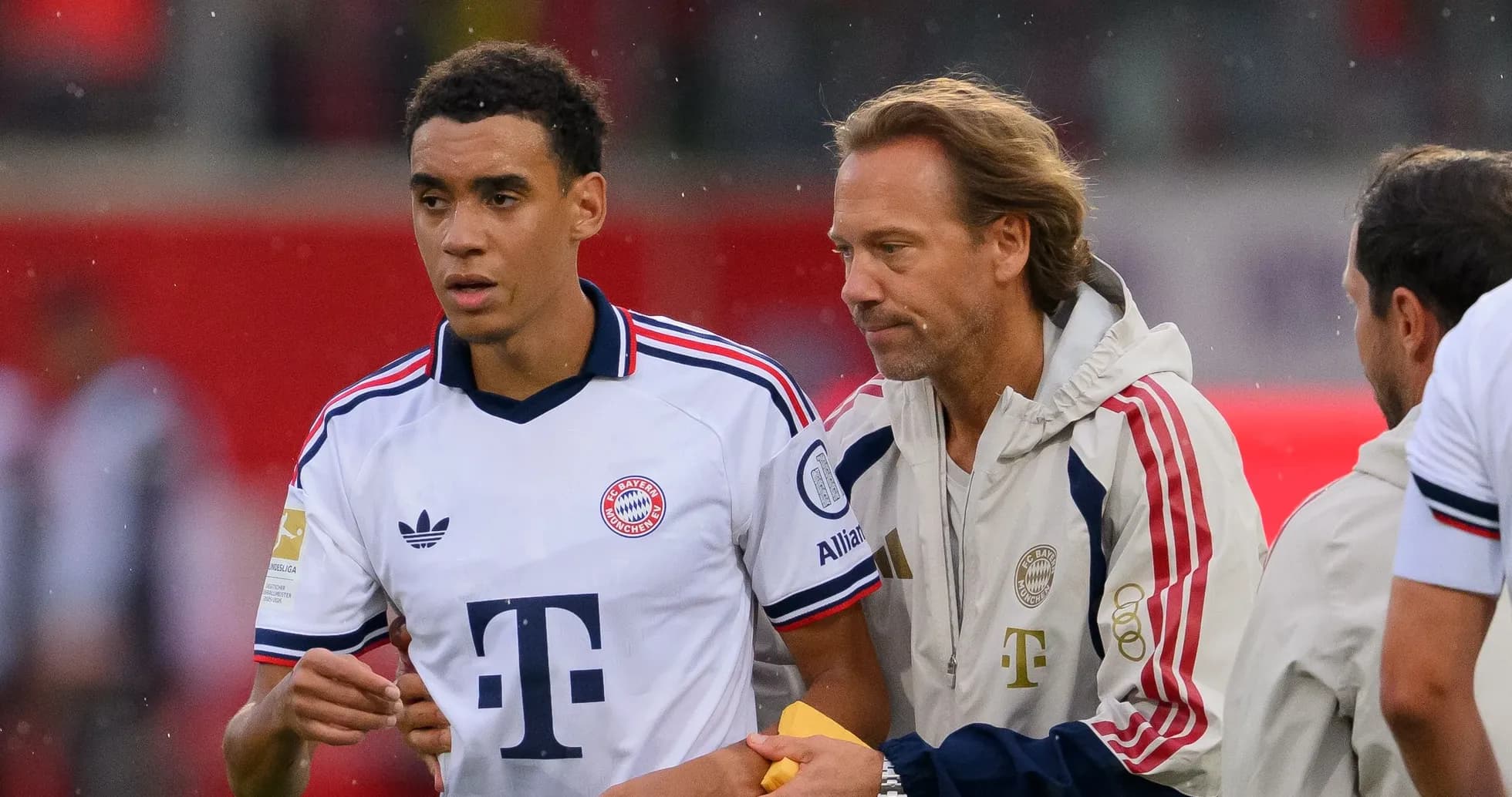 Jugador de Bayern Múnich siendo atendido por entrenador Jugador de Bayern Múnich siendo atendido por entrenador